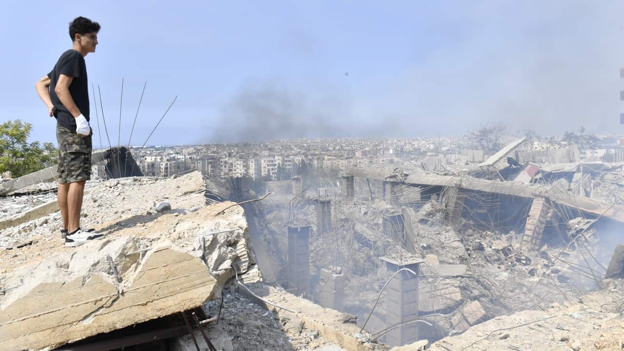 A person looks over wreckage following an airstrike.
