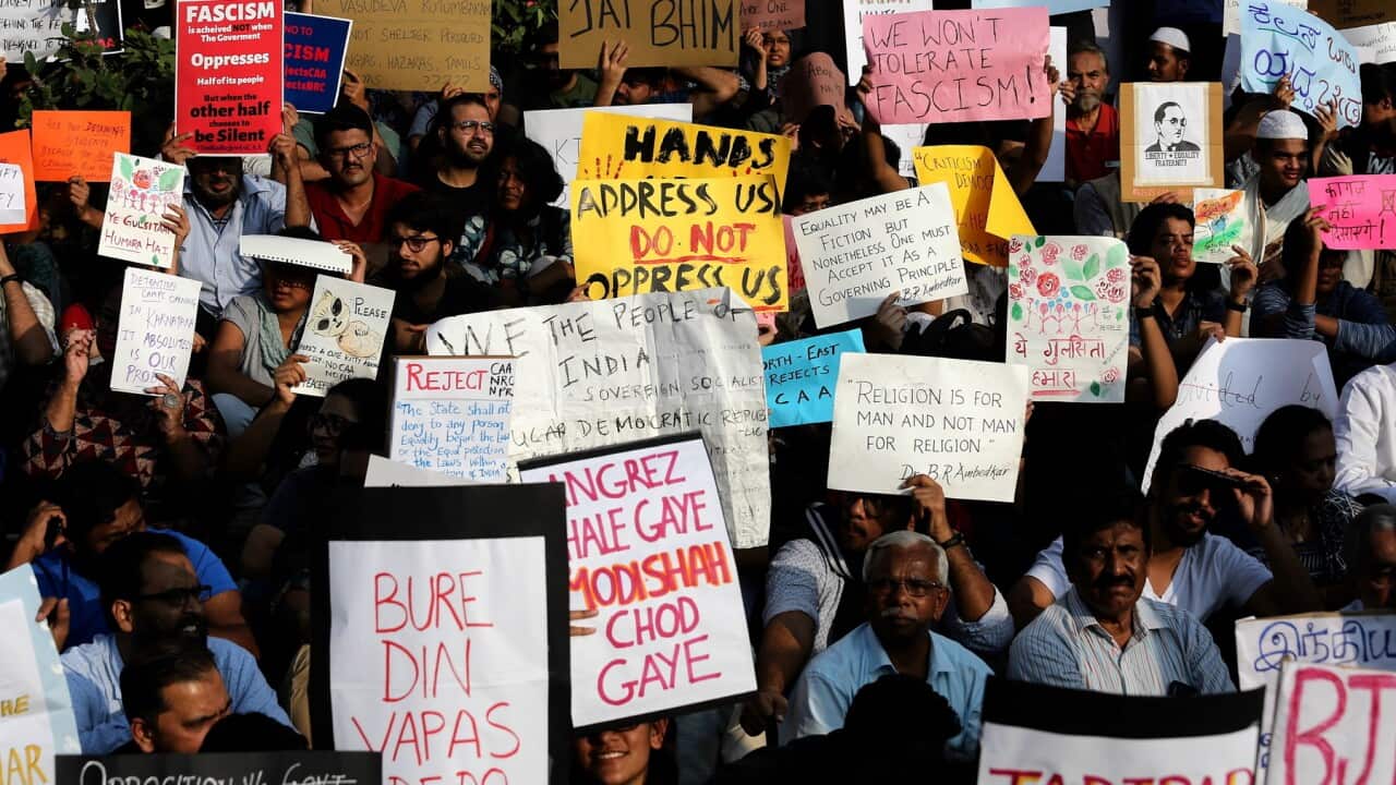 Indian protesters hold placards and shout slogans during a protest
