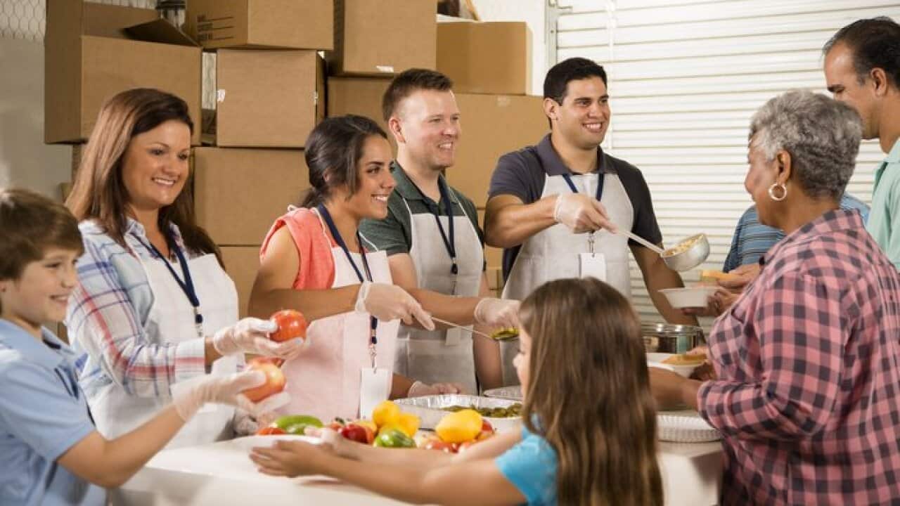 group of volunteers serving food to a family