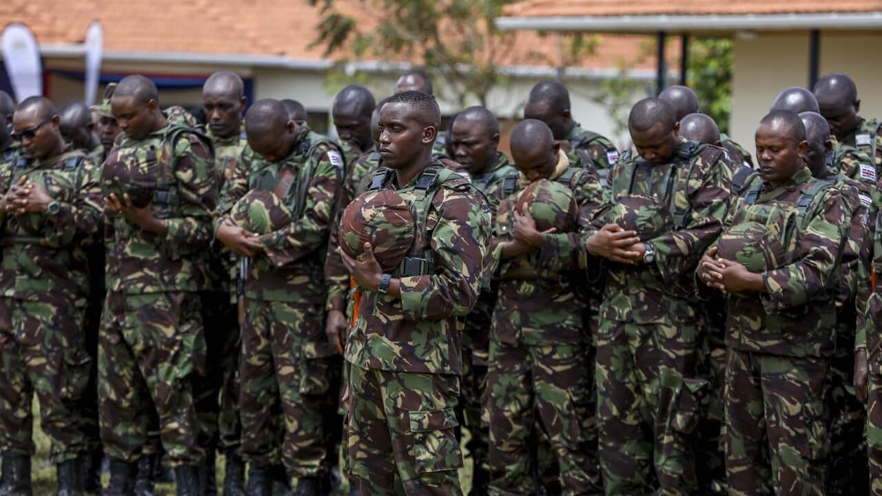 Kenya Defence Forces soldiers pray during a ceremony with President William Ruto