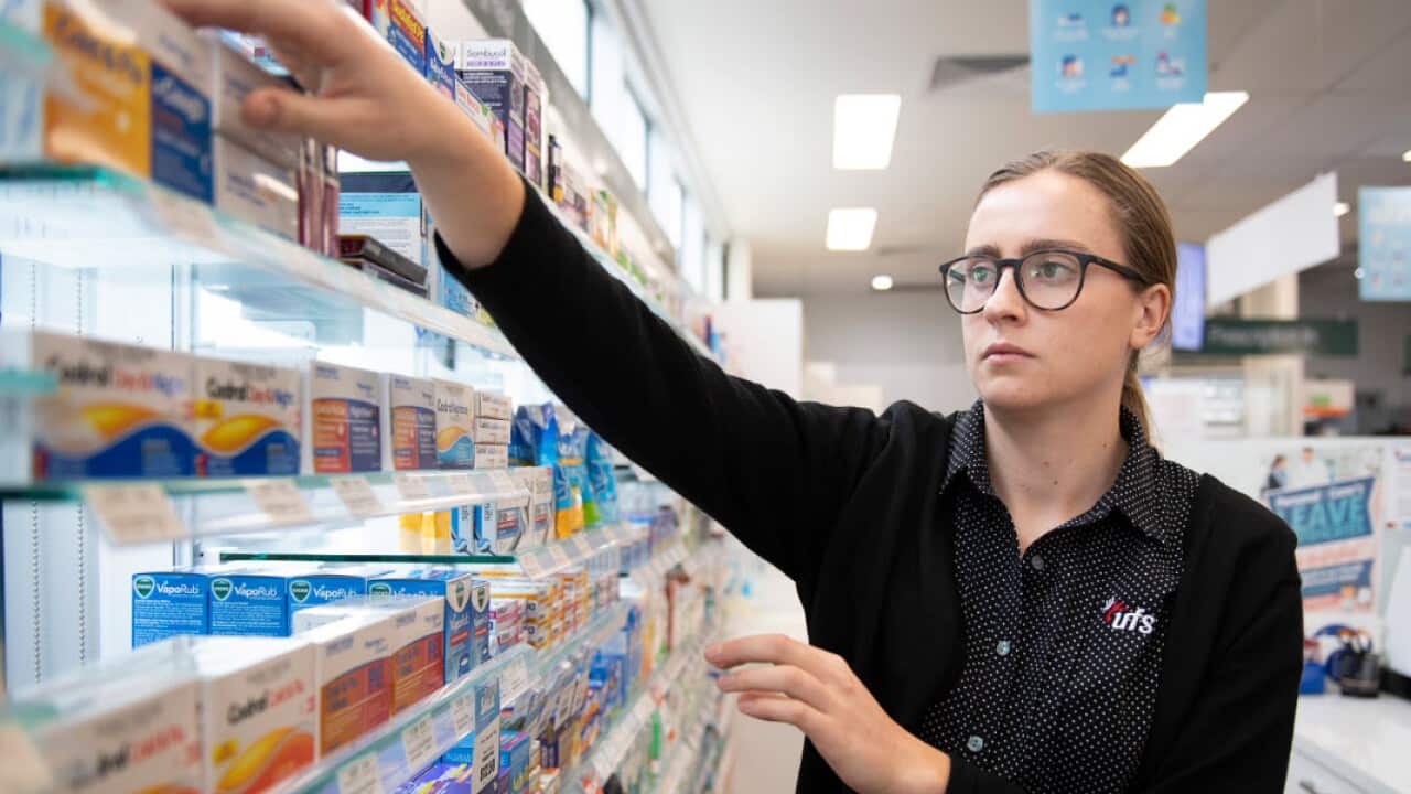 A pharmacist reaches for medicine at a shop in Coburg, Melbourne