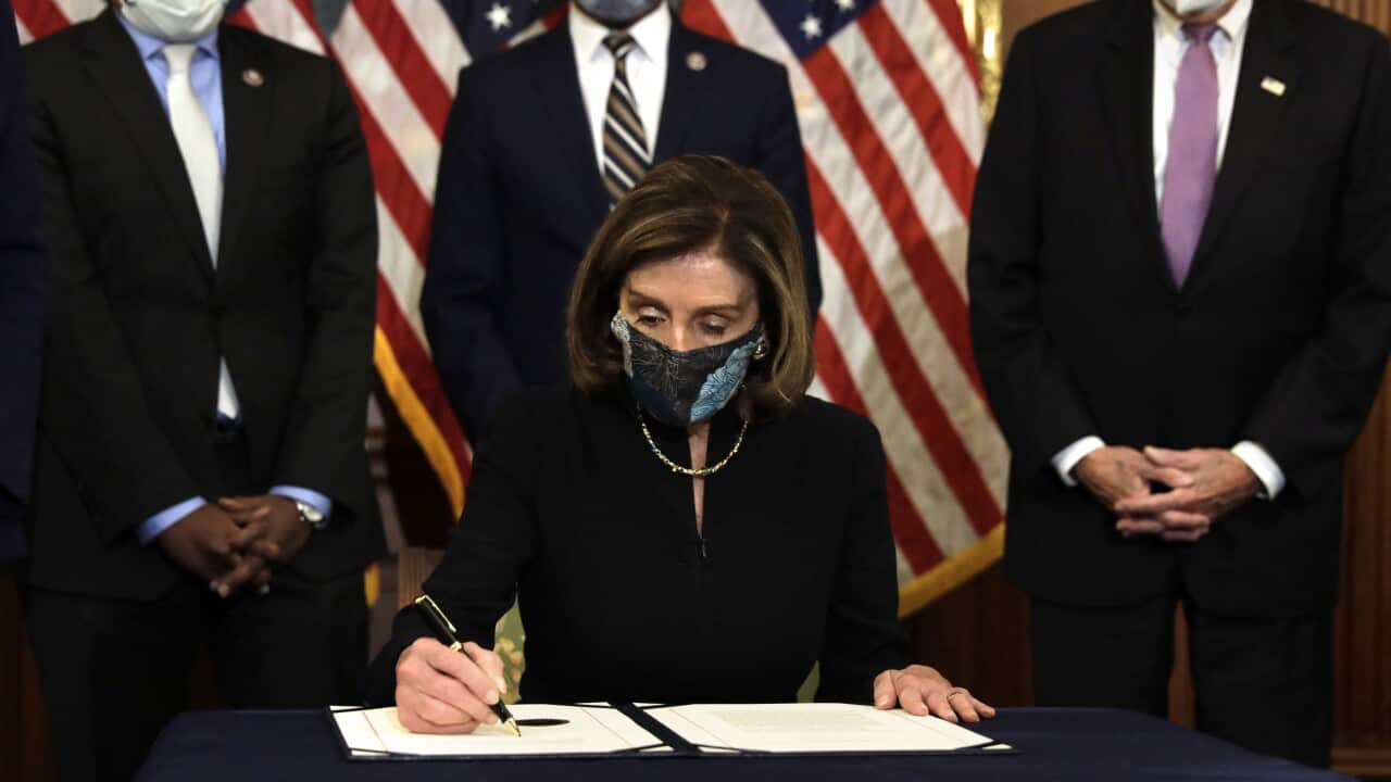 Nancy Pelosi signs the article of the impeachment against President Donald Trump