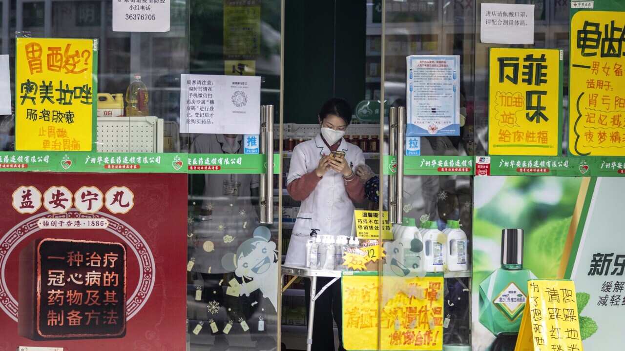 A woman stands in a pharmacy in the Yaotai Community close to African Village in Guangzhou, Guangdong province.