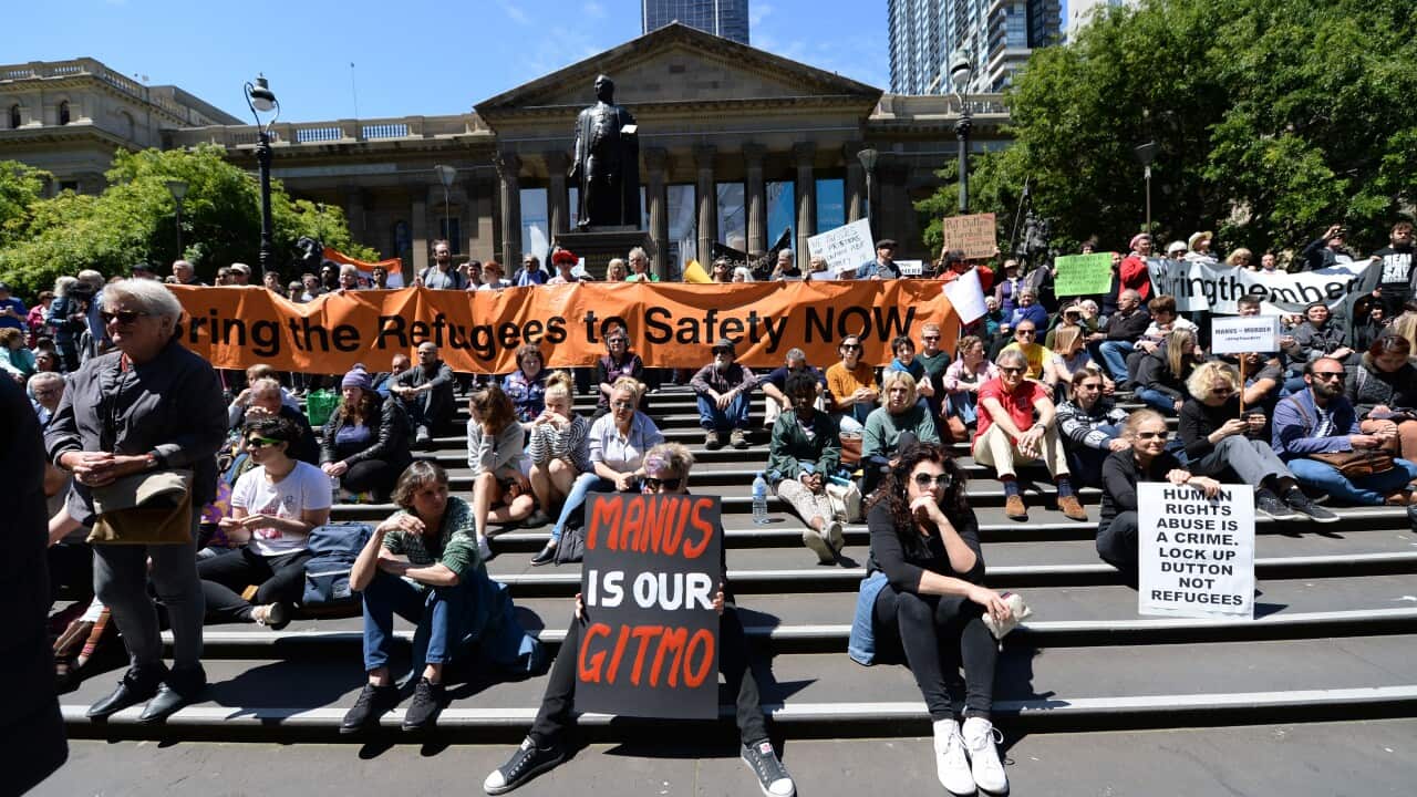Protesters rally with the Refugee Action Collective outside the Victorian state library.