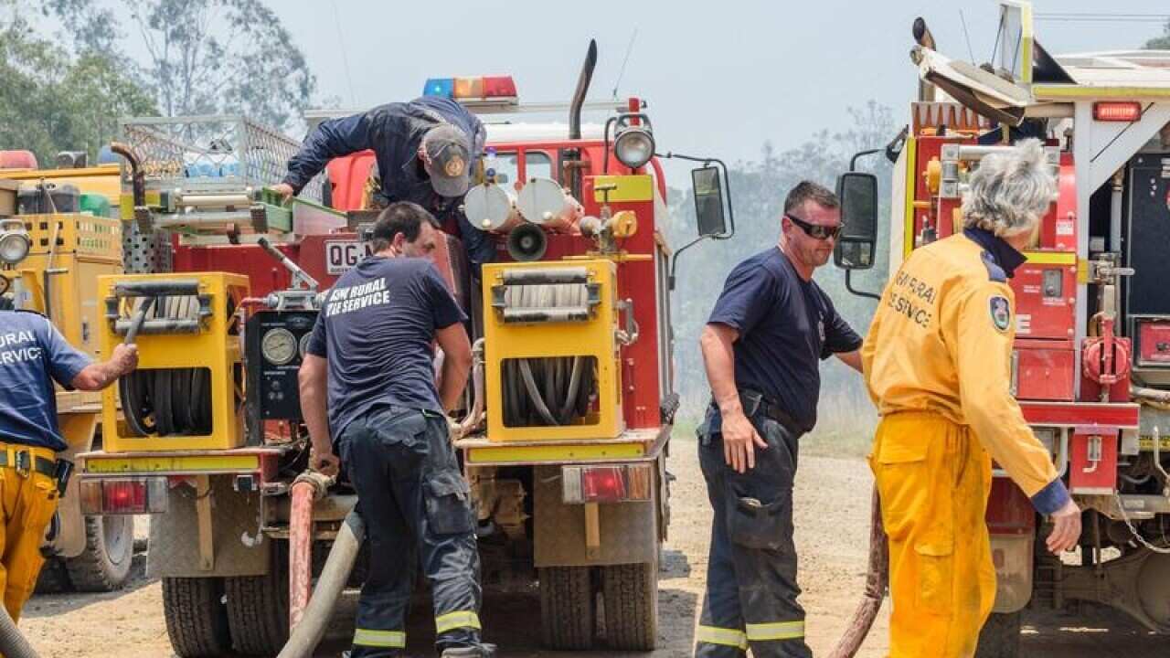 Firefighters refill their fire trucks