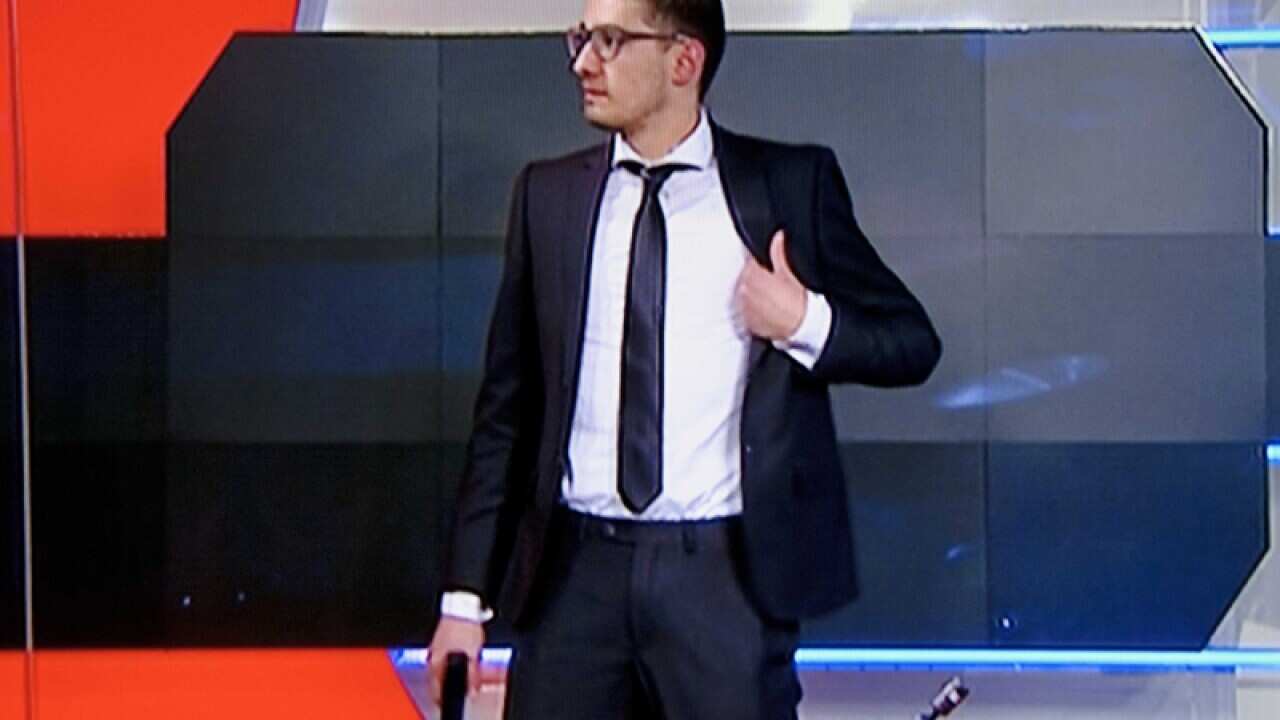 A gunman in the studio shortly before he was arrested.