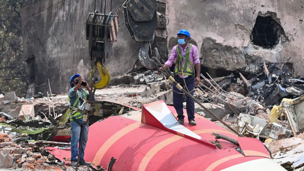 The wreckage of the crashed Air India plane is being lifted by a crane from the roof of the BJ Medical College mess building