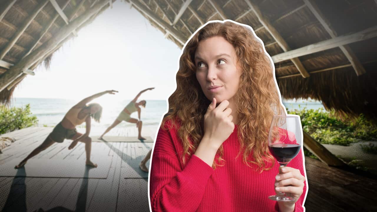 A woman in a red sweater holding a glass of red wine, looking sideways, superimposed over a picture of three people doing yoga by the sea to her right.