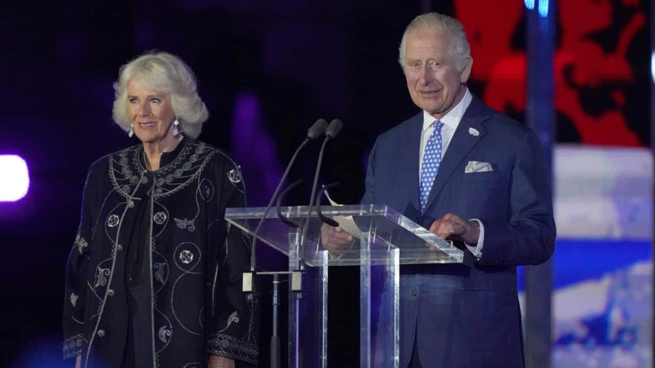 A man and woman stand on stage.