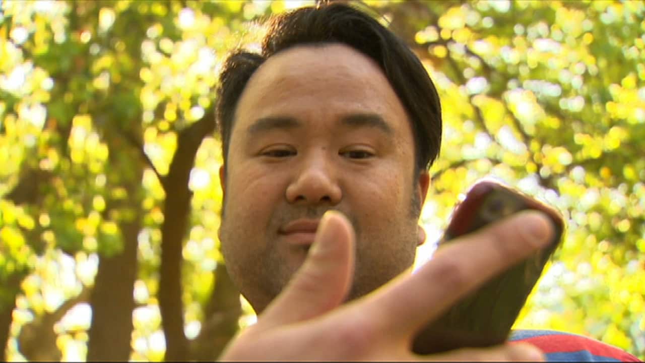 Terry Koo uses his smart phone.