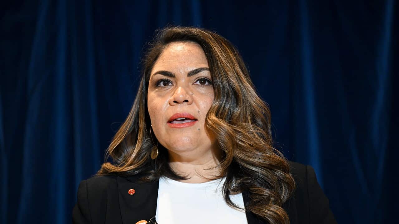 Jacinta Price wearing a white shirt and black blazer speaking at a podium