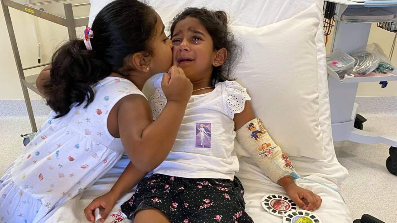 Tharnicaa (right) in hospital on Christmas Island with her sister, Kopika, before being medically evacuated to Australia.