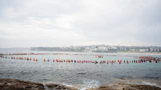 Surfers lining up in a large circle in the water