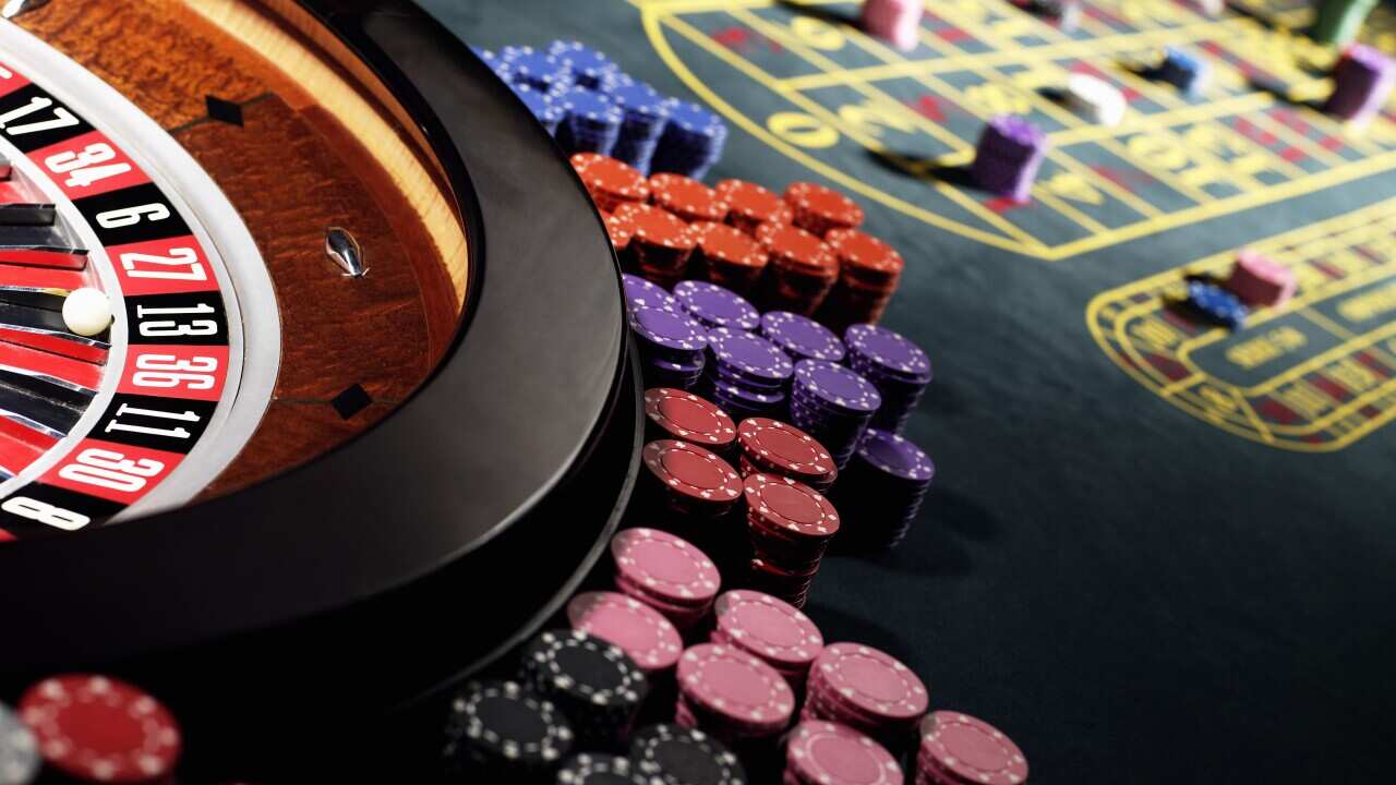 Gambling chips stacked around roulette wheel on gaming table