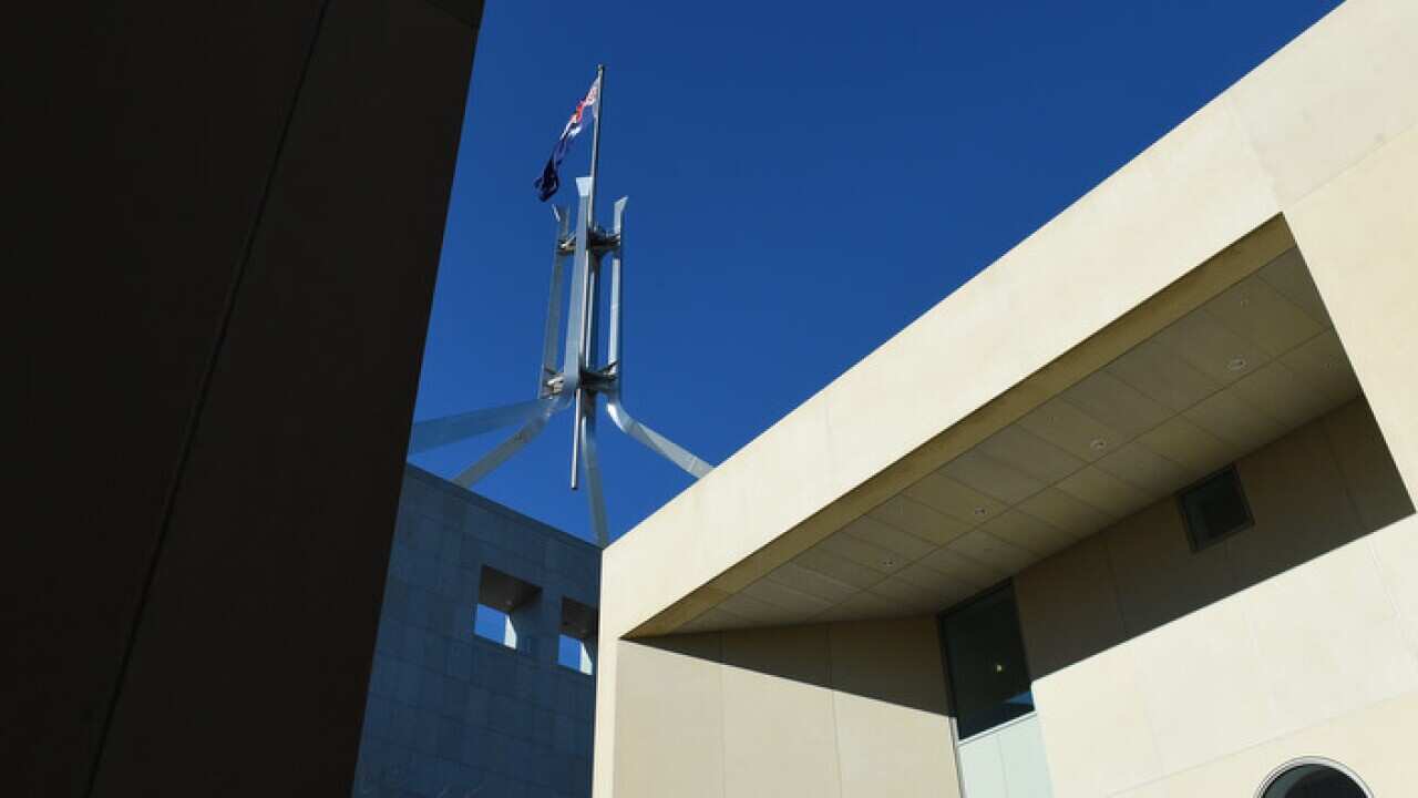 The Australian flag is seen above Parliament House in Canberra, Thursday, Aug. 13, 2015. (AAP Image/Mick Tsikas) NO ARCHIVING