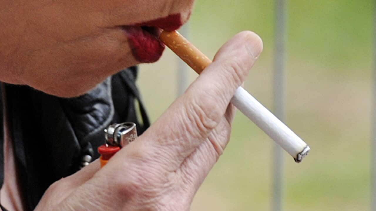 A woman smokes a cigarette.