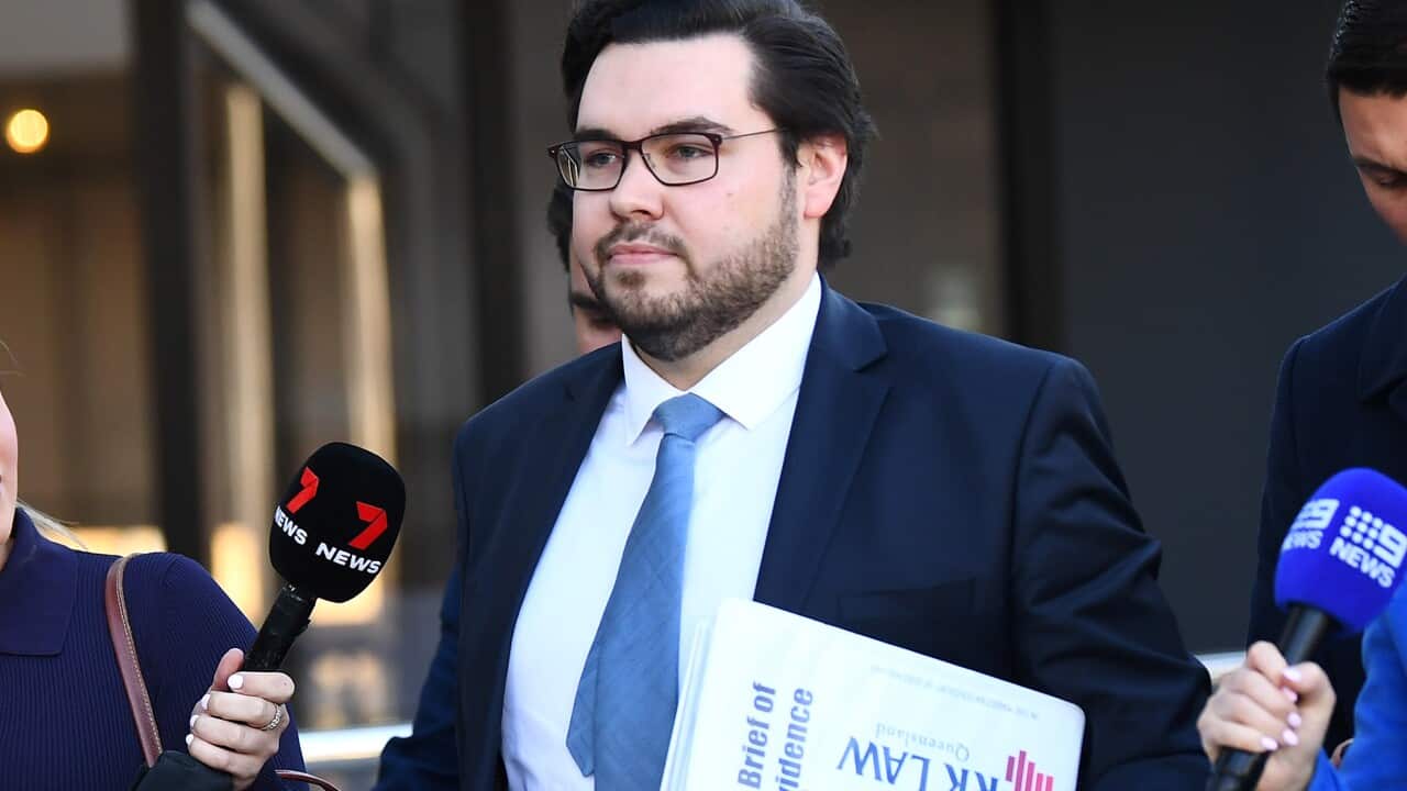 A man wearing a suit and tie leaves court.
