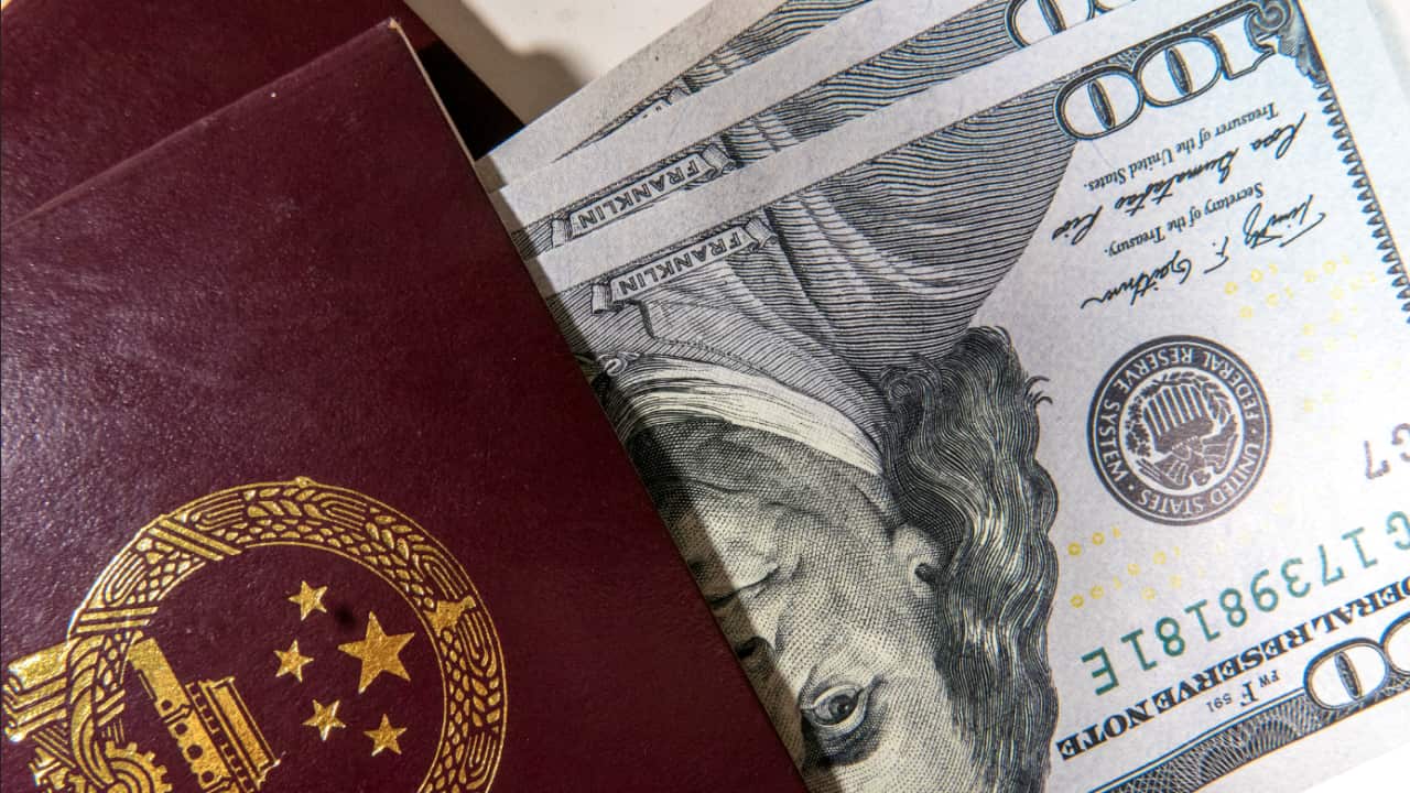 US Dollar banknotes folded in the passport of China.