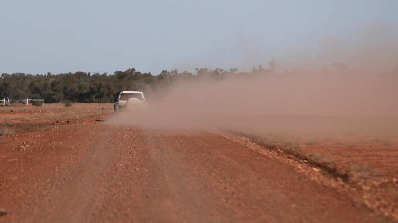 Ute kicking up red dust in QLD