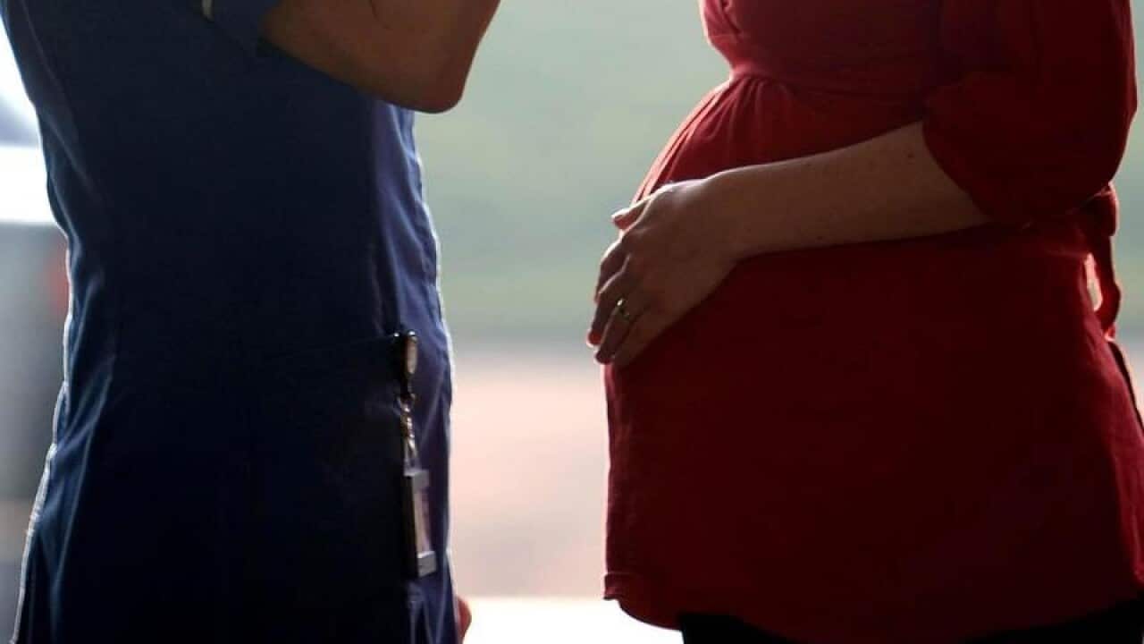 A midwife talking to a pregnant woman.