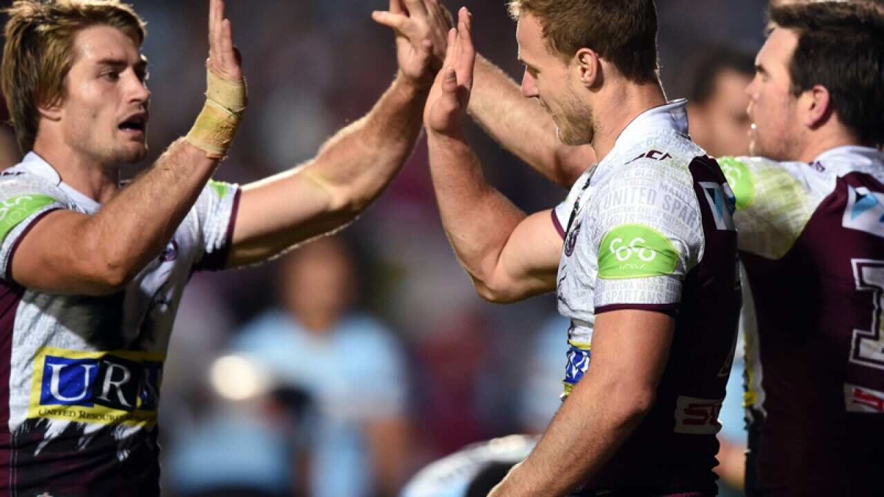 Daly Cherry-Evans (C) of the Manly Sea Eagles and Kieran Foran (L)