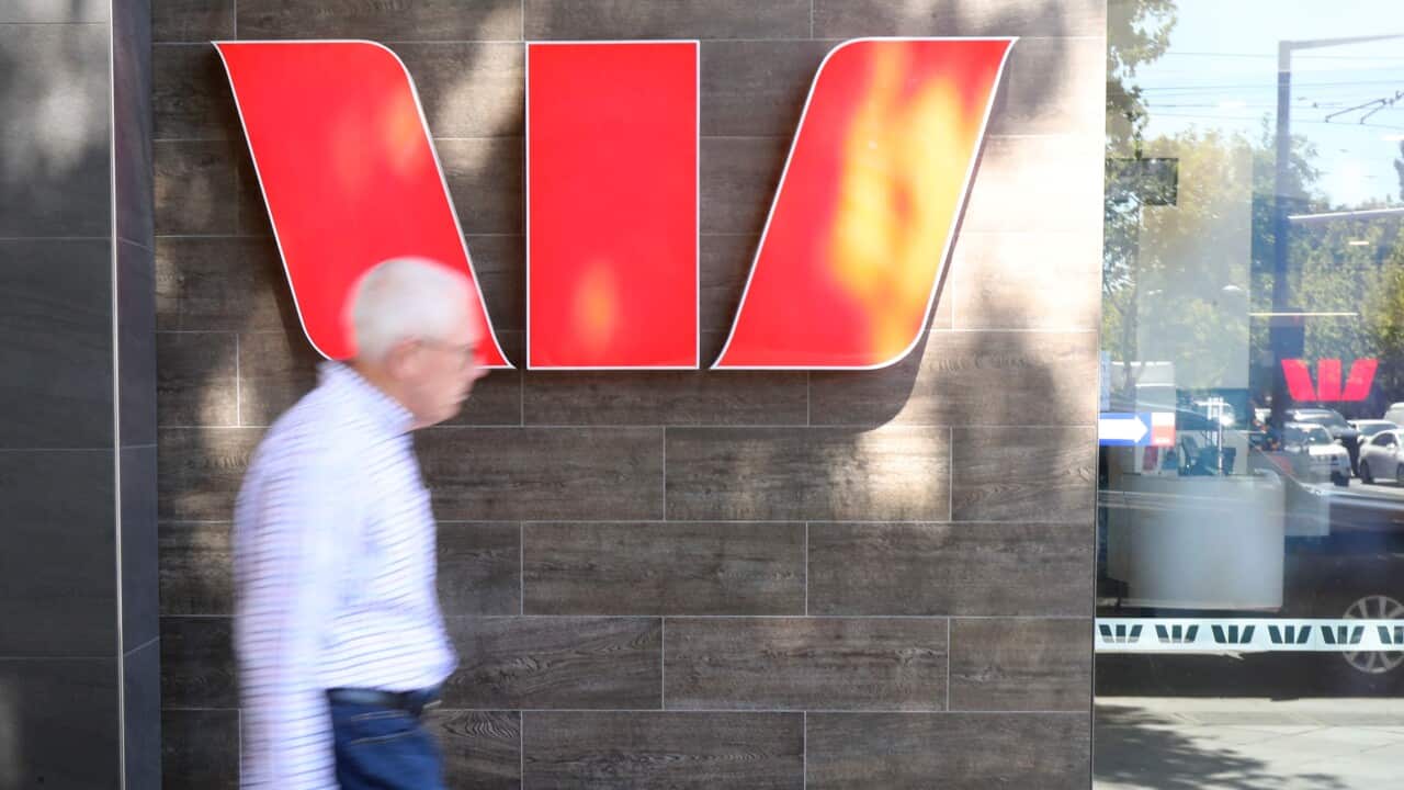 People walking past a Westpac sign