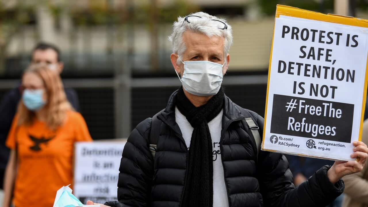 Protesters hold placards during a "Free The Refugees" rally at Sydney Town Hall in Sydney, Saturday, June 13, 2020. The Supreme Court on Thursday prohibited the protest from going ahead. (AAP Image/Bianca De Marchi) NO ARCHIVING