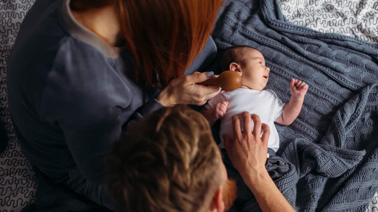 Young parents giving of attention to their baby.