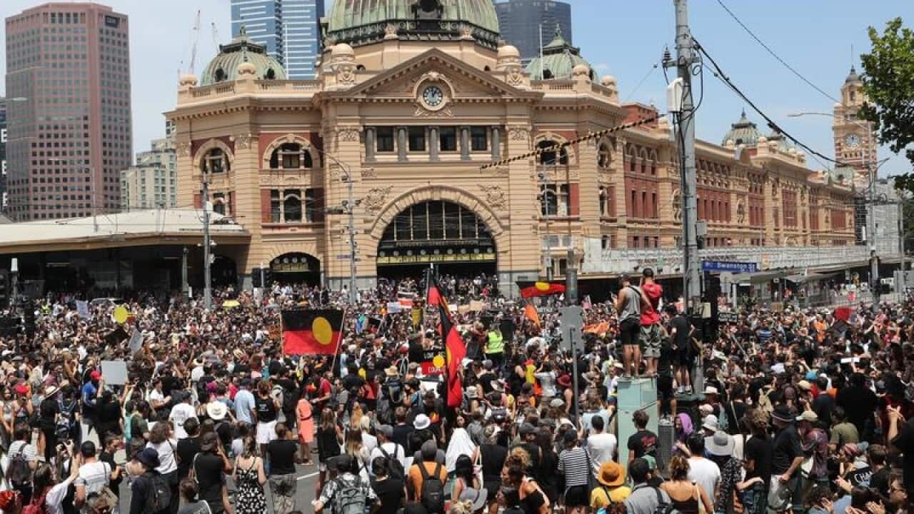 A large crowd of protesters in front of Flinders St Station