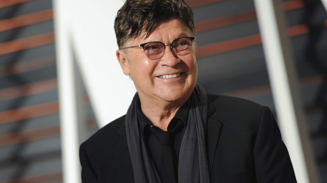 Robbie Robertson smiling at the camera.