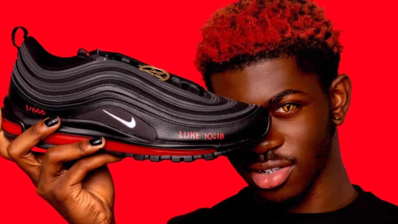 Lil Nas X holding the "demonic" shoes disputed by original maker Nike.
