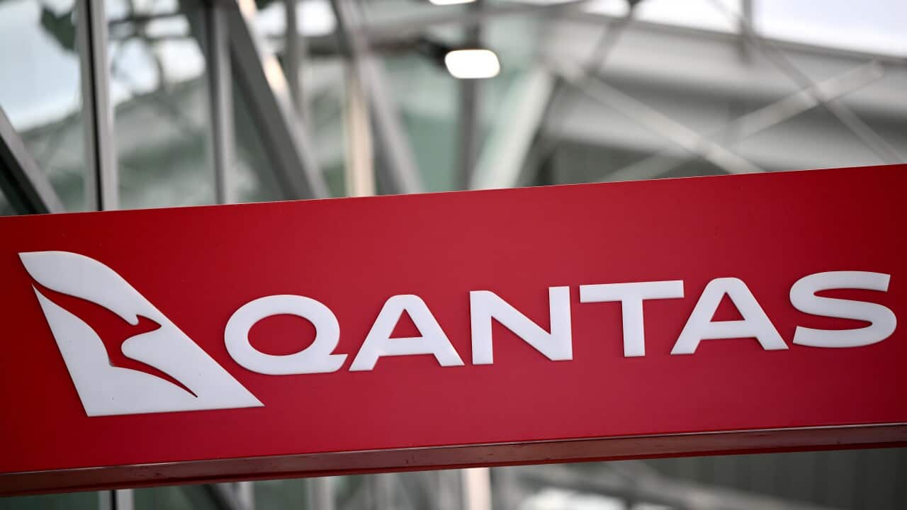 A red sign that reads QANTAS with the airline's kangaroo logo.
