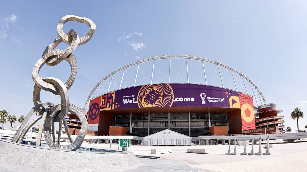A sculpture outside a stadium with a sign saying 'welcome'