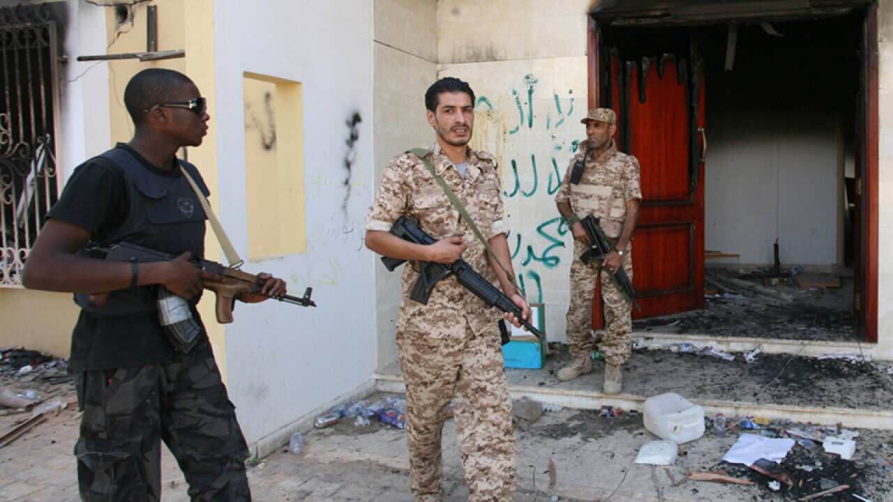 Libyan military guards check a burnt out buildings, Benghazi, Libya