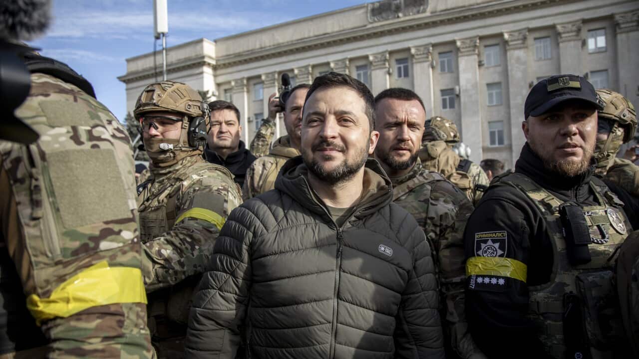 President Zelenskyy smiling in Kherson, surrounded by Ukrainian soldiers