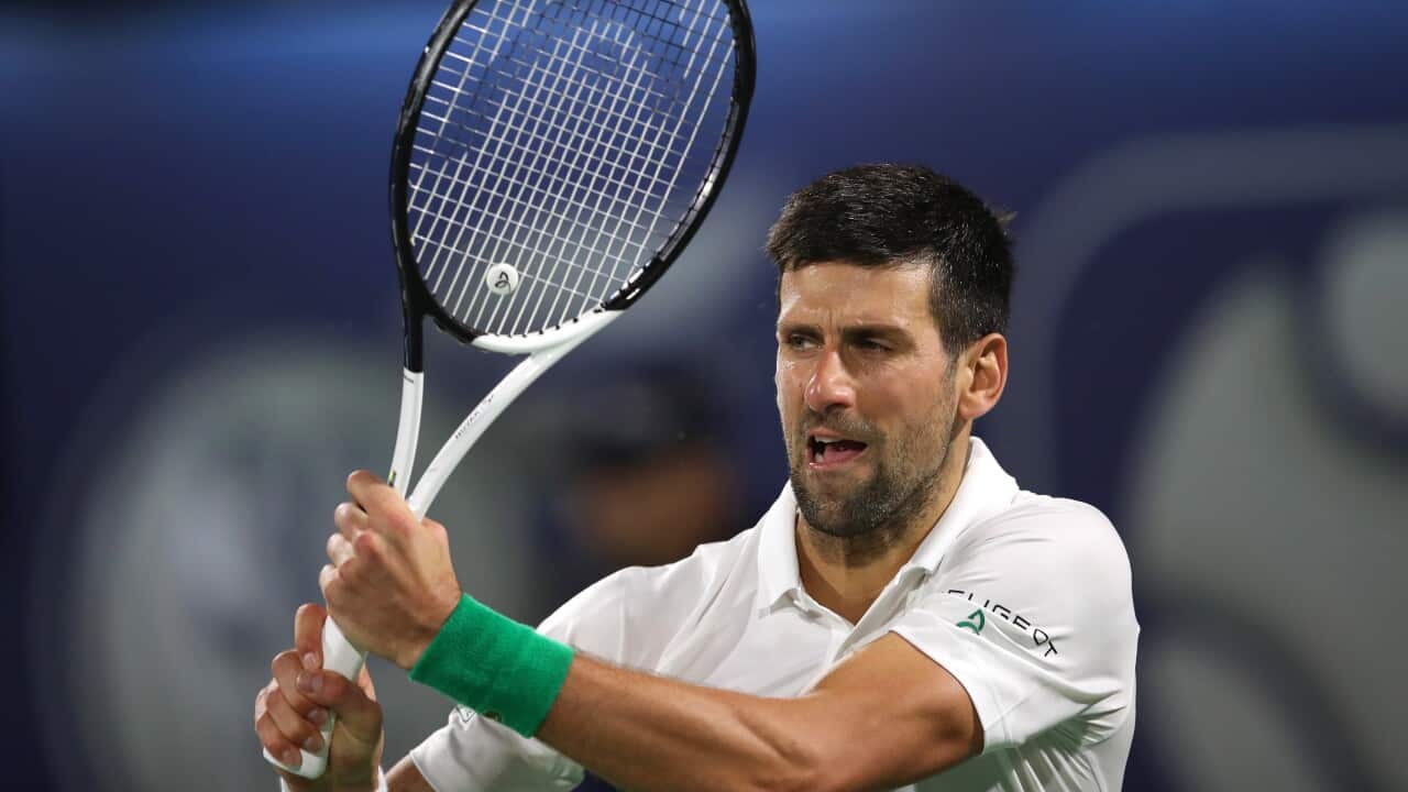Novak Djokovic is seen holding a tennis racquet during a match.