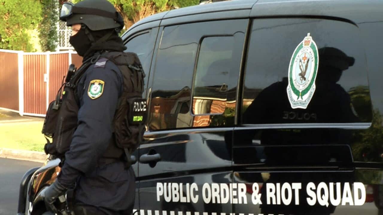 A Public Order and Riot Squad officer waiting during a raid in Sydney
