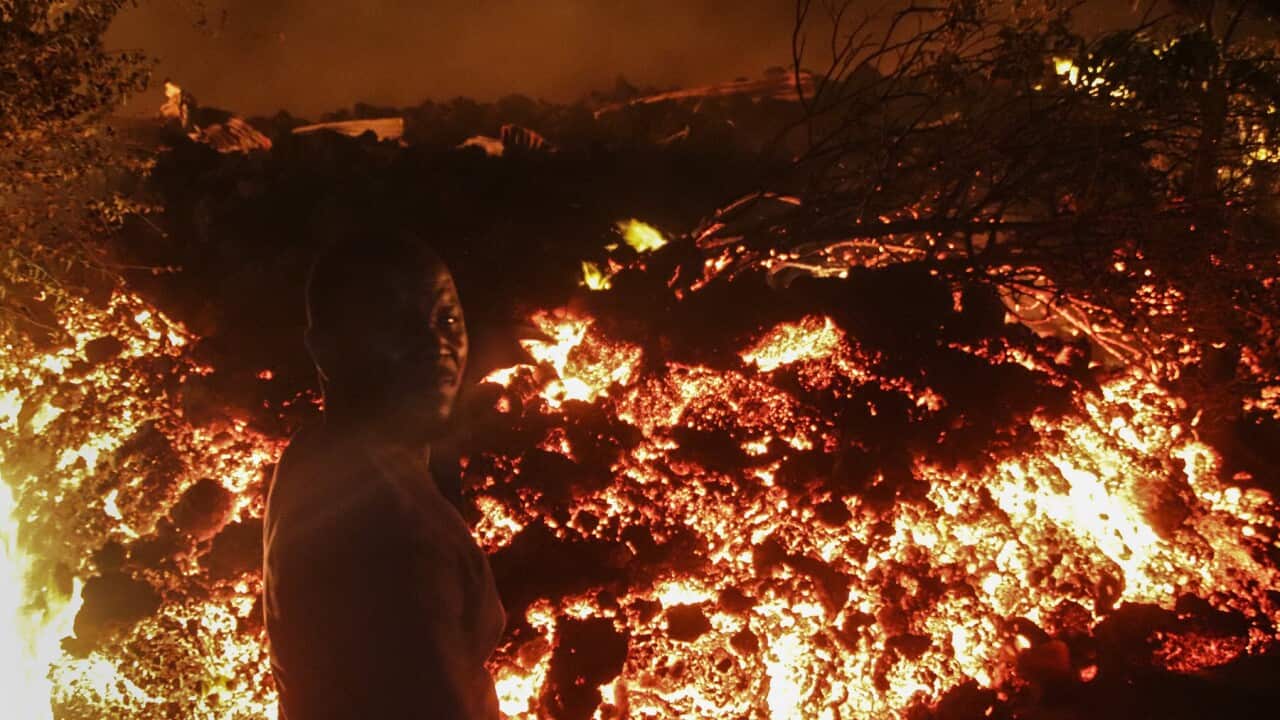 A man stands in front of lava on the outskirts of Goma