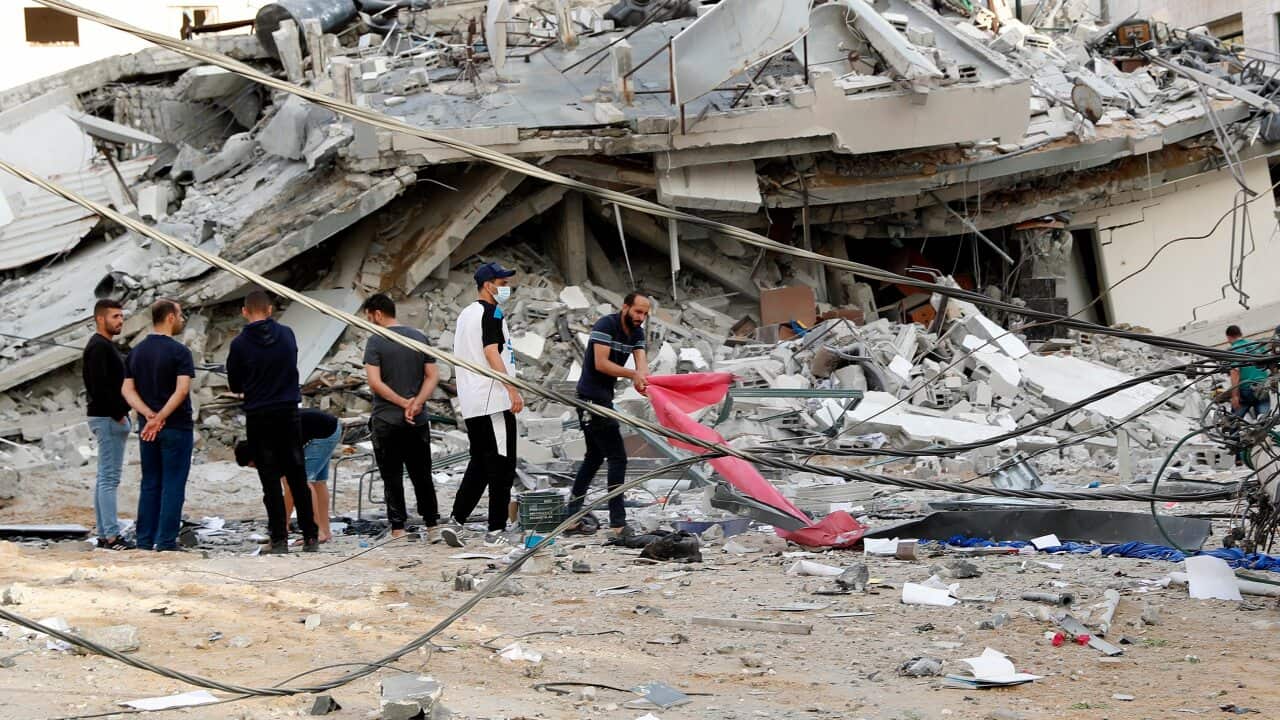 Residents inspect the rubble of a destroyed building that was hit by an Israeli airstrike in Gaza City.