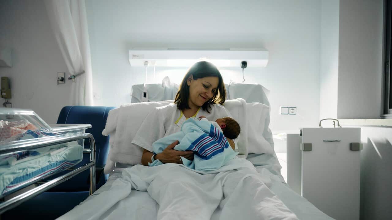 a smiling mother after breastfeeding her newborn