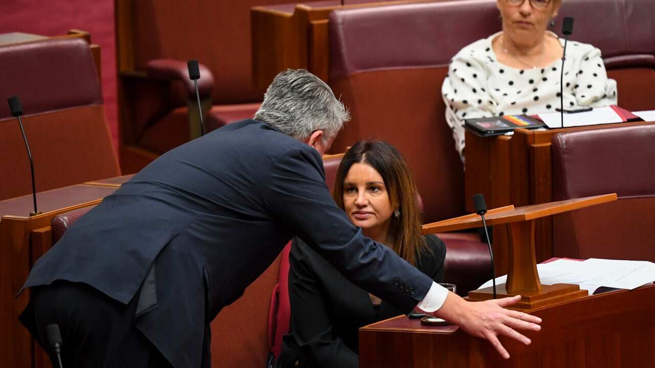 Crossbench Senator Jacqui Lambie (right) speaks with the Leader of the Government in the Senate Mathias Cormann.