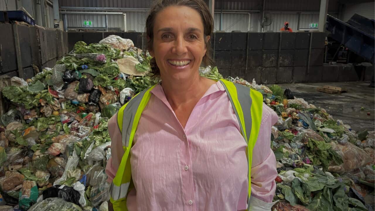 Olympia Yarger standing in front of a pile of vegetable produce food waste