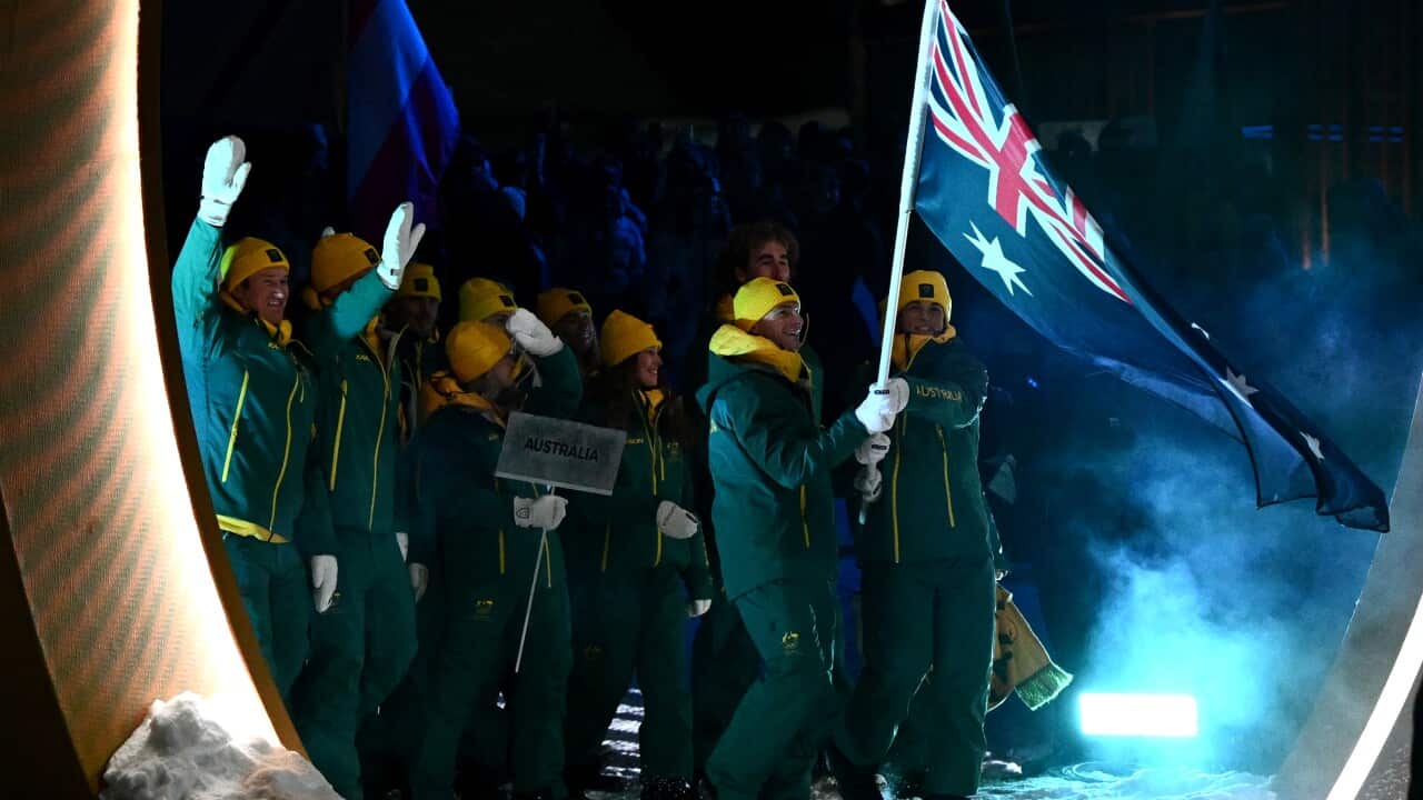 The Australian contingent at the 2026 Winter Olympics opening ceremony wearing green and gold and carrying an Australian flag