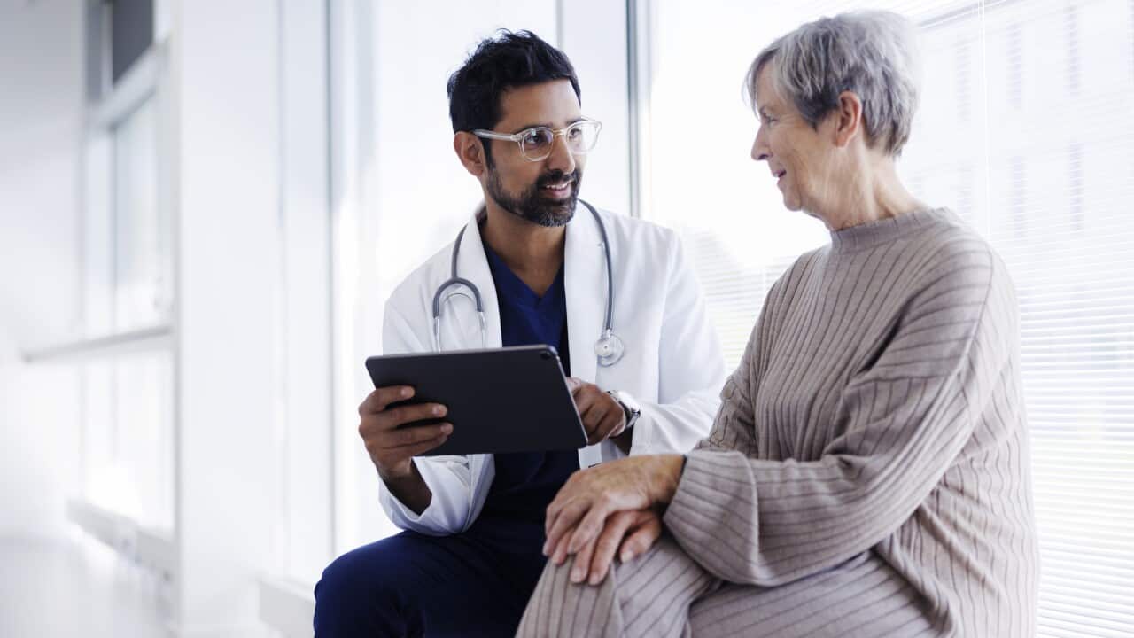 Doctor and patient in conversation, looking at digital tablet