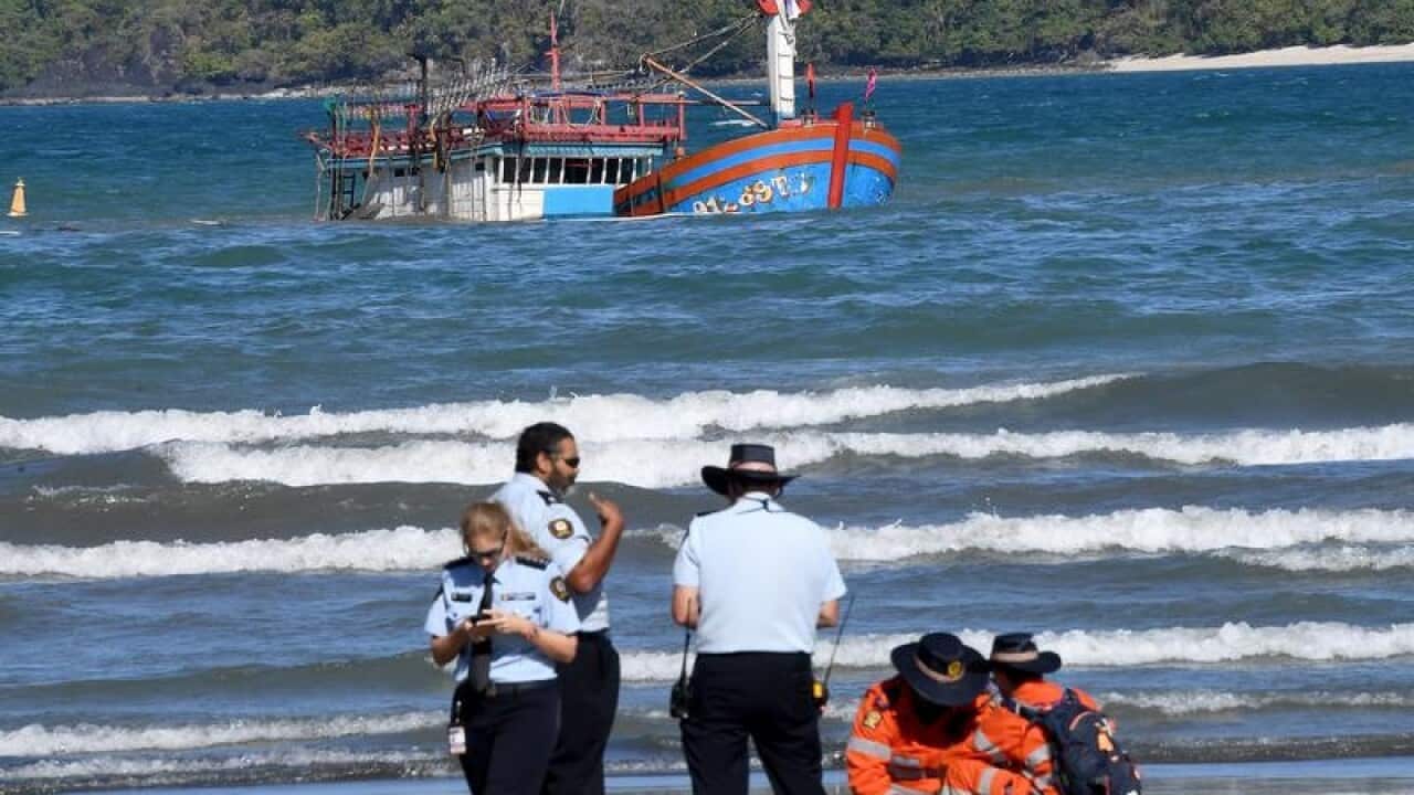 Police inspect a sunken vessel that carried asylum seekers.