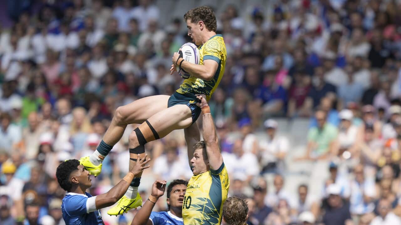 Australia's Ben Dowling, top, takes a high ball supported by teammate Australia's Nick Malouf during the men's Rugby Sevens Pool B match between Australia and Samoa