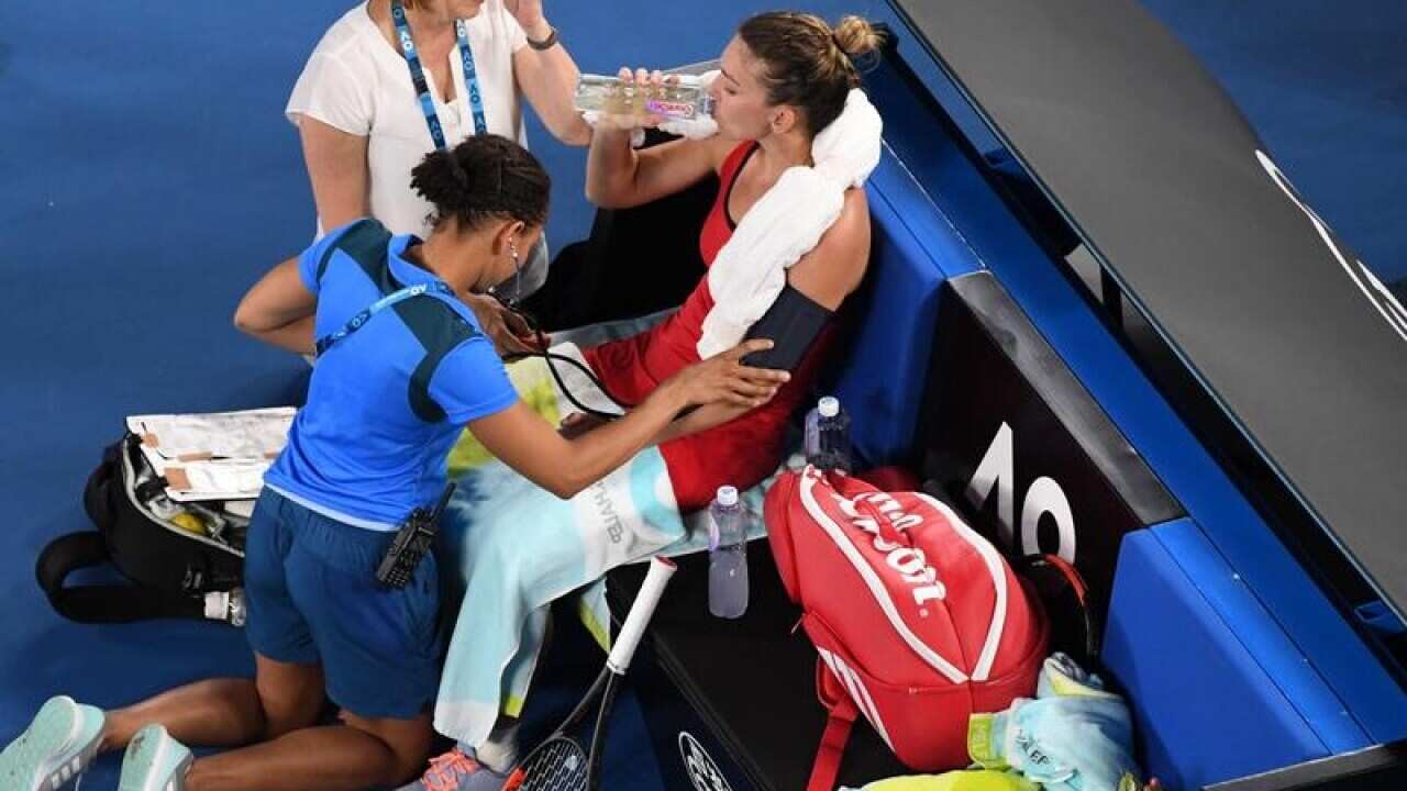 Simona Halep receives medical attention during a break in play.
