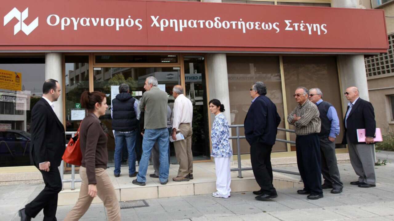 People outside a branch of Cyprus' Housing Finance Corporation