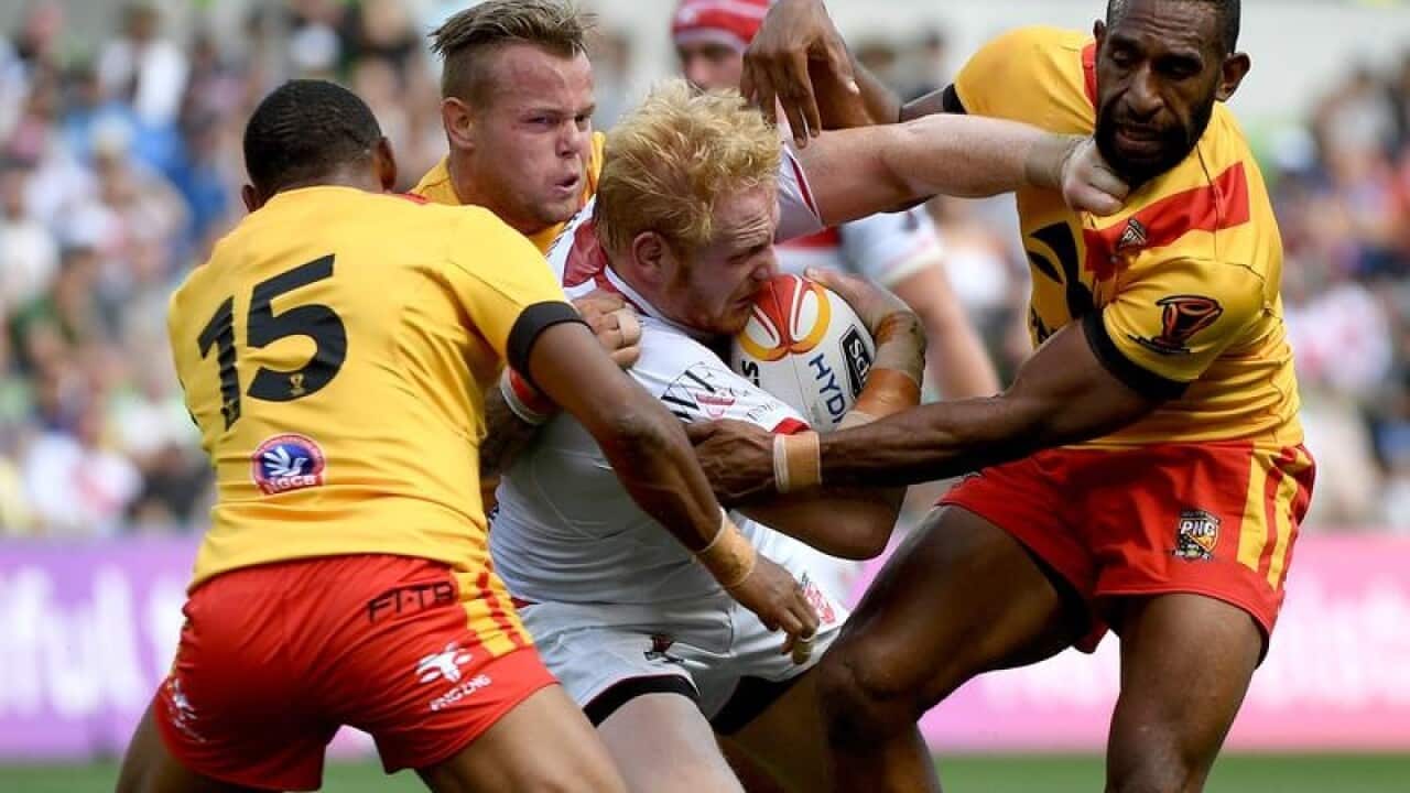 James Graham of England tackled by Luke Page and Moses Meninga of PNG.