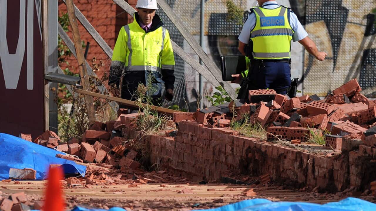Emergency workers near the site where a brick wall collapsed
